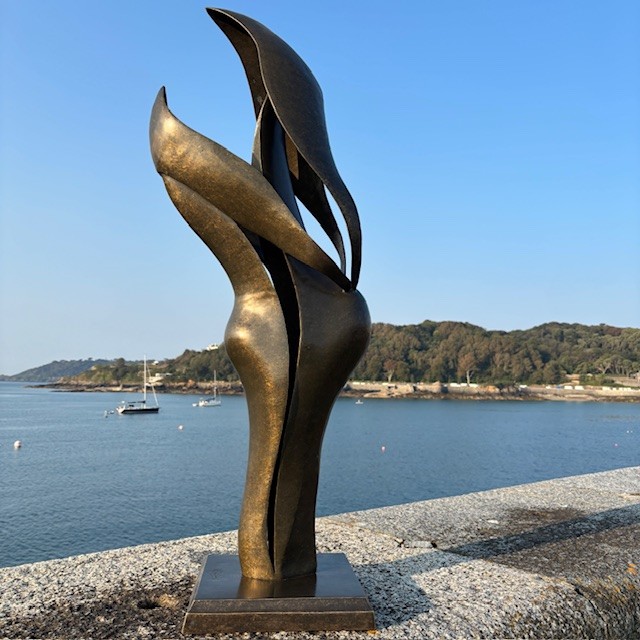 Large Harmony bronze sculpture displayed overlooking St Peter Port harbour in Guernsey on a sunny day.