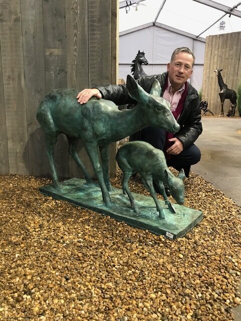 Verdigris bronze deer doe and fawn sculpture in natural garden setting