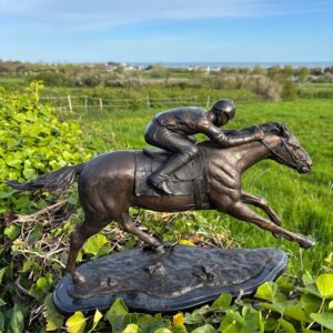 Pursuit of Victory racehorse and jockey bronze sculpture galloping in countryside setting