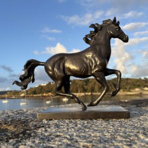 Solid Bronze Horse Galloping Sculpture HO 26 opposite side view with raised foreleg and coastal Guernsey backdrop