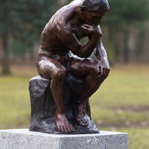 Bronze thinker sculpture inspired by Rodin showing a seated male nude in deep contemplation