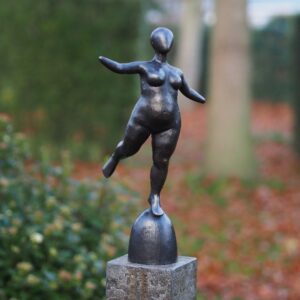 Modern bronze balancing female figure sculpture standing on rounded base