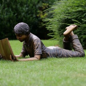 Young Student Boy Lying Down Reading Book Bronze Sculpture FIBO 2 3 | Avant Garden Bronzes
