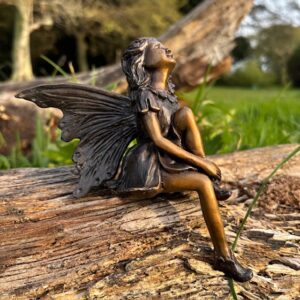 Bronze fairy looking up seated on log garden sculpture gift