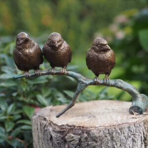 three little birds perched on a twig for interior decor or a garden corner.