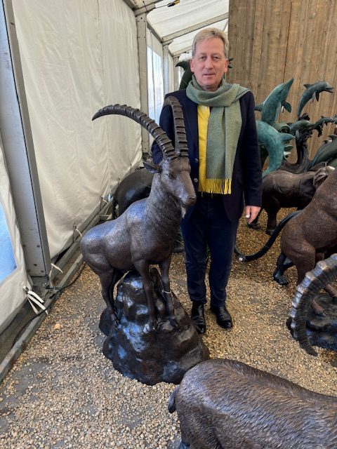 Ibex mountain goat on rock bronze sculpture displayed in garden