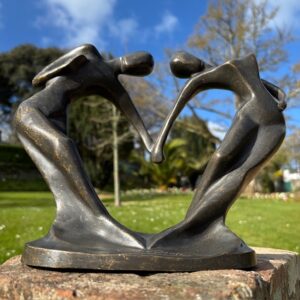 Abstract bronze lovers heart sculpture forming heart shape romantic garden or interior ornament in brown bronze patina