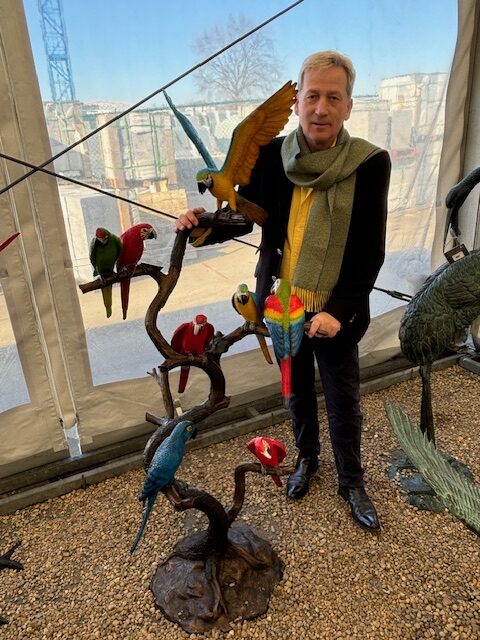 Bronze parrot flock sculpture with eight colourful parrots perched in tall bronze tree