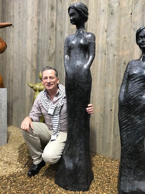 Tall elegant bronze lady feminine garden sculpture in planting