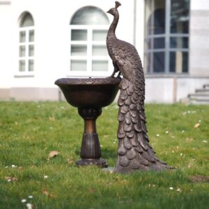 Bronze peacock fountain sculpture on pedestal bowl with flowing water in formal estate garden