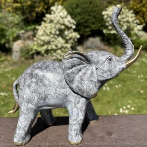 The Lucky Elephant Bronze Sculpture WI 52 full side profile elephant sculpture with uplifted trunk on outdoor bench