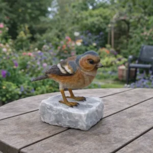Small Amber Chaffinch Bird Bronze Sculpture BI 116 detailed bronze chaffinch ornament on white stone surrounded by colourful garden planting