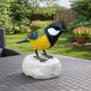 Small Golden Great Tit Bird Bronze Sculpture BI 112 perched on natural stone base with vibrant yellow, green and black plumage in garden setting