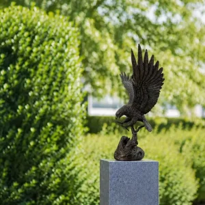 Eagle Landing On Tree Stump Bronze Sculpture with powerful spread wings, detailed feathers and sharp talons in a garden setting BI 125