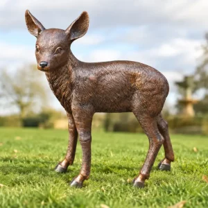 Fawn Bronze Deer Garden Sculpture with finely detailed coat, slender legs and gentle lifelike expression, standing naturally among garden greenery.
