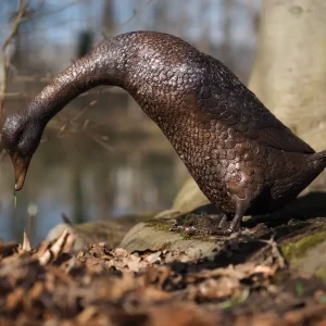 Feeding Duck Bronze Garden Sculpture BI 122 beside water in a natural woodland setting