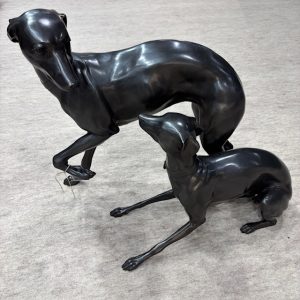 Bronze Whippets The Long And The Little dog pair sculpture featuring standing and resting whippets with elegant lifelike detail.